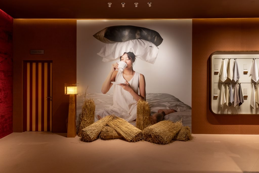 Raw-grass forms beneath an expressive bedroom photograph