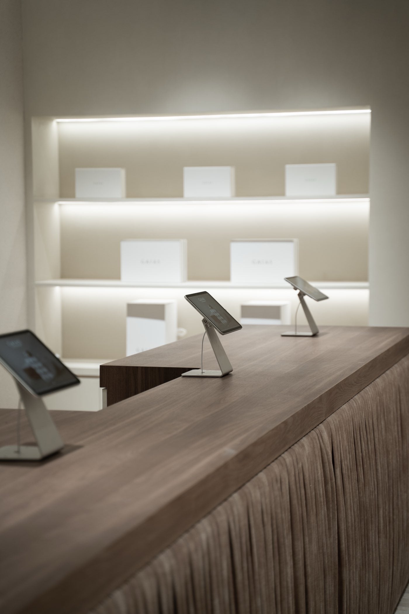 Gift boxes on lit shelving behind the fluted timber counter