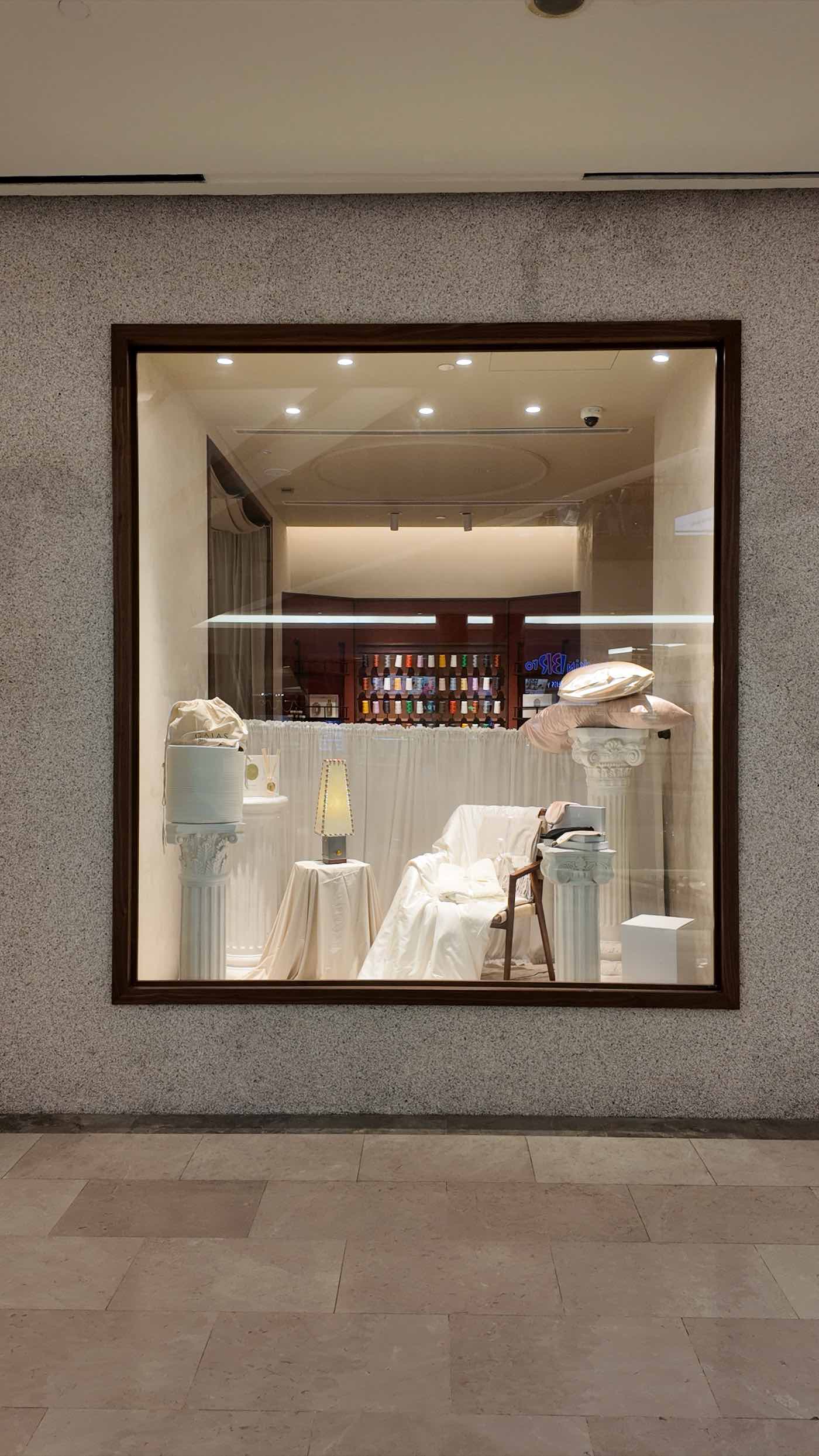 The framed mall window, with the thread-spool wall beyond